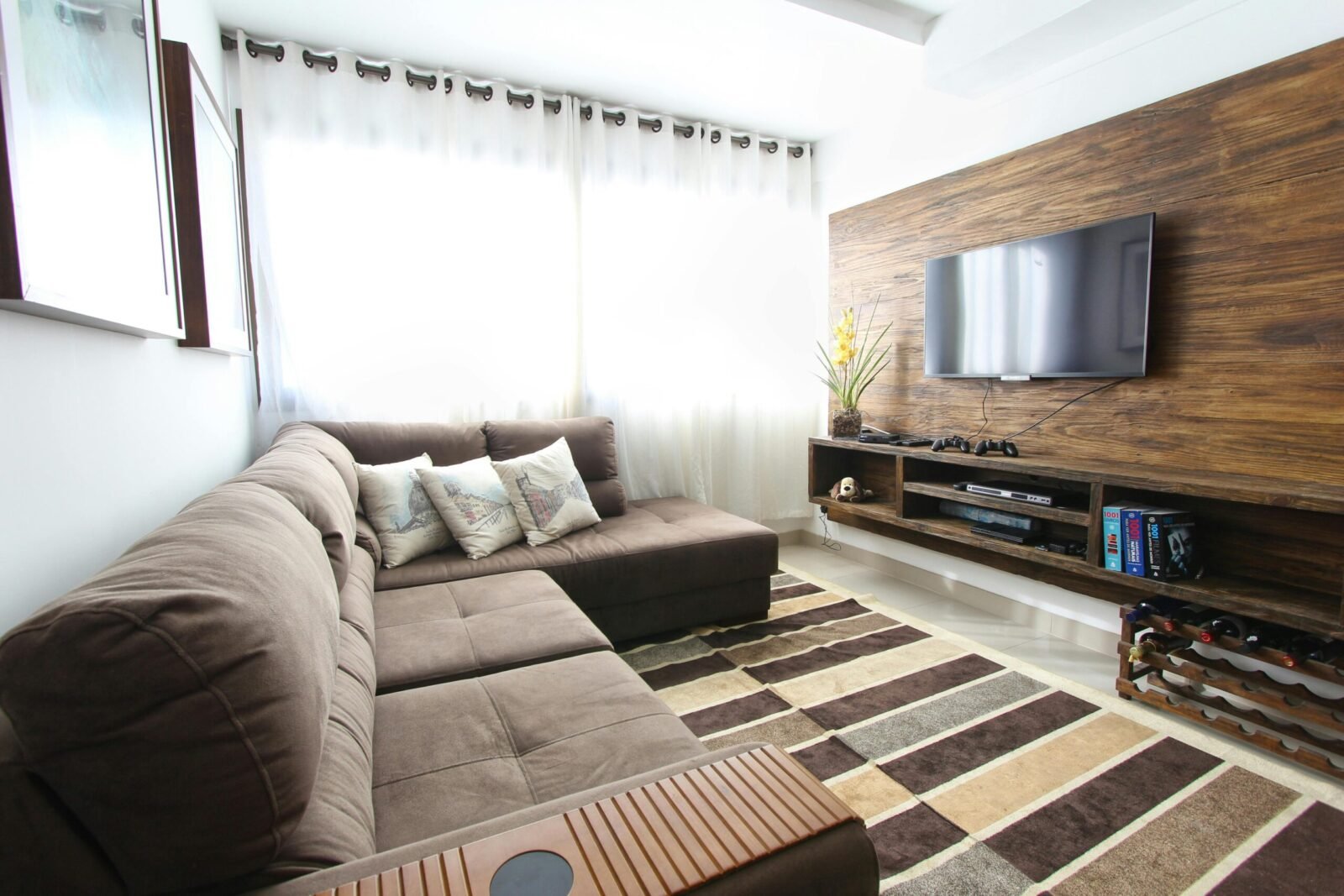 Stylish modern living room featuring a brown sofa, wall-mounted TV, and interior decor.
